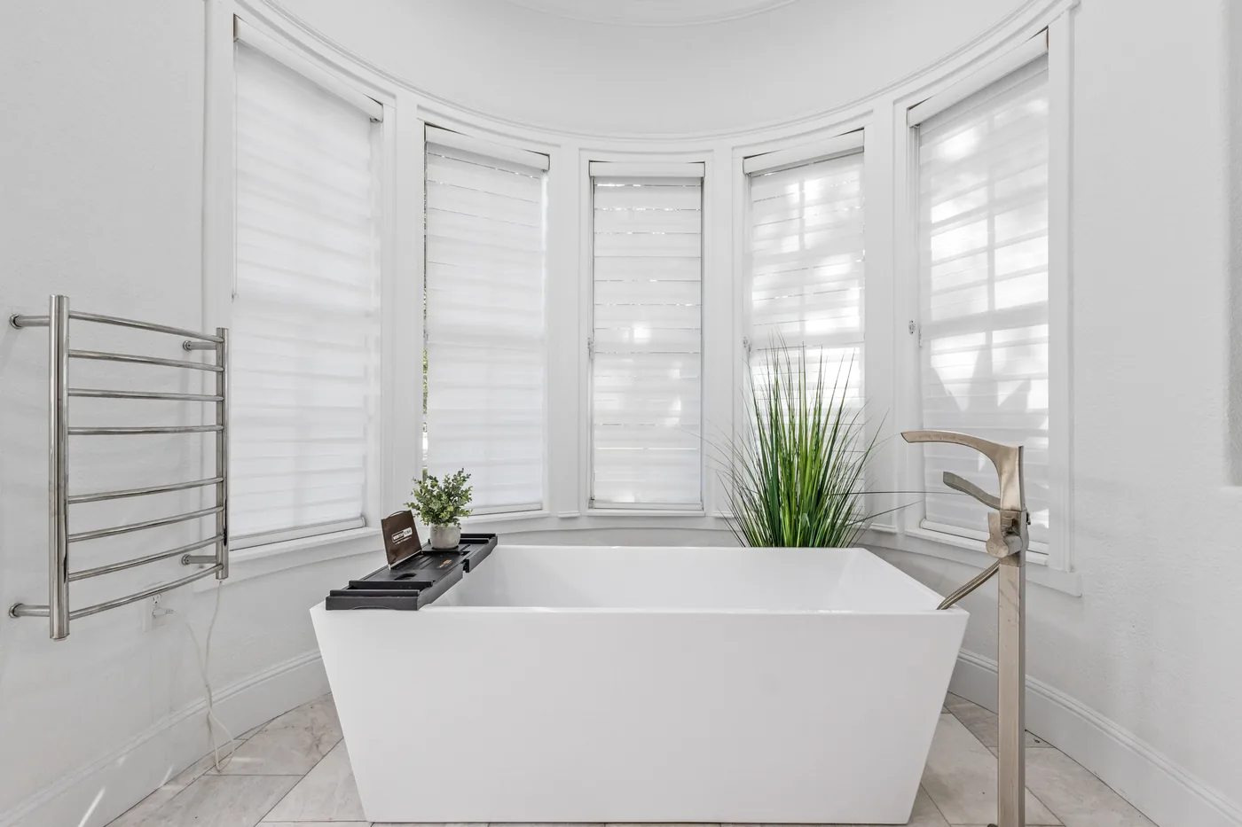 Luxury primary bathroom with freestanding soaking tub - professional interior real estate photography by REMIX Central Florida