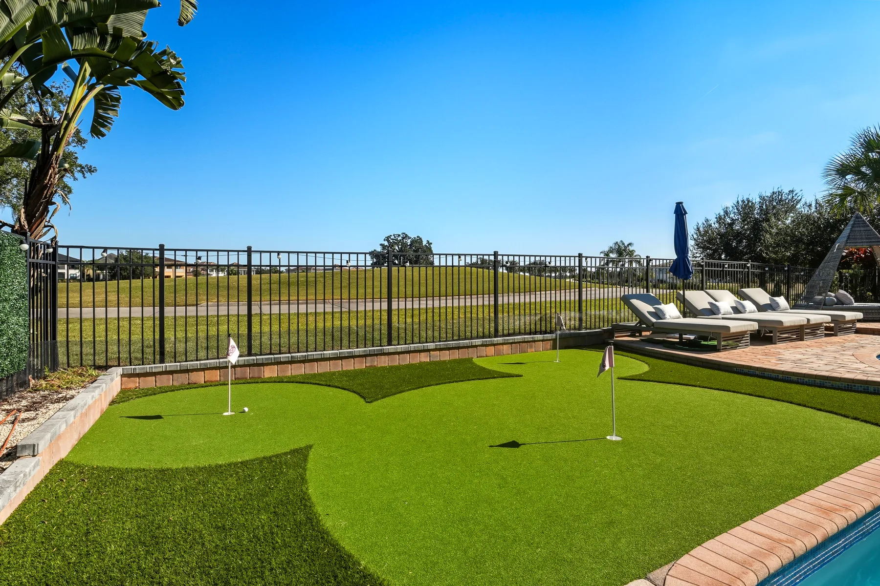 Luxury backyard putting green and pool photography - real estate listing media by REMIX Real Estate Media 9, Central Florida